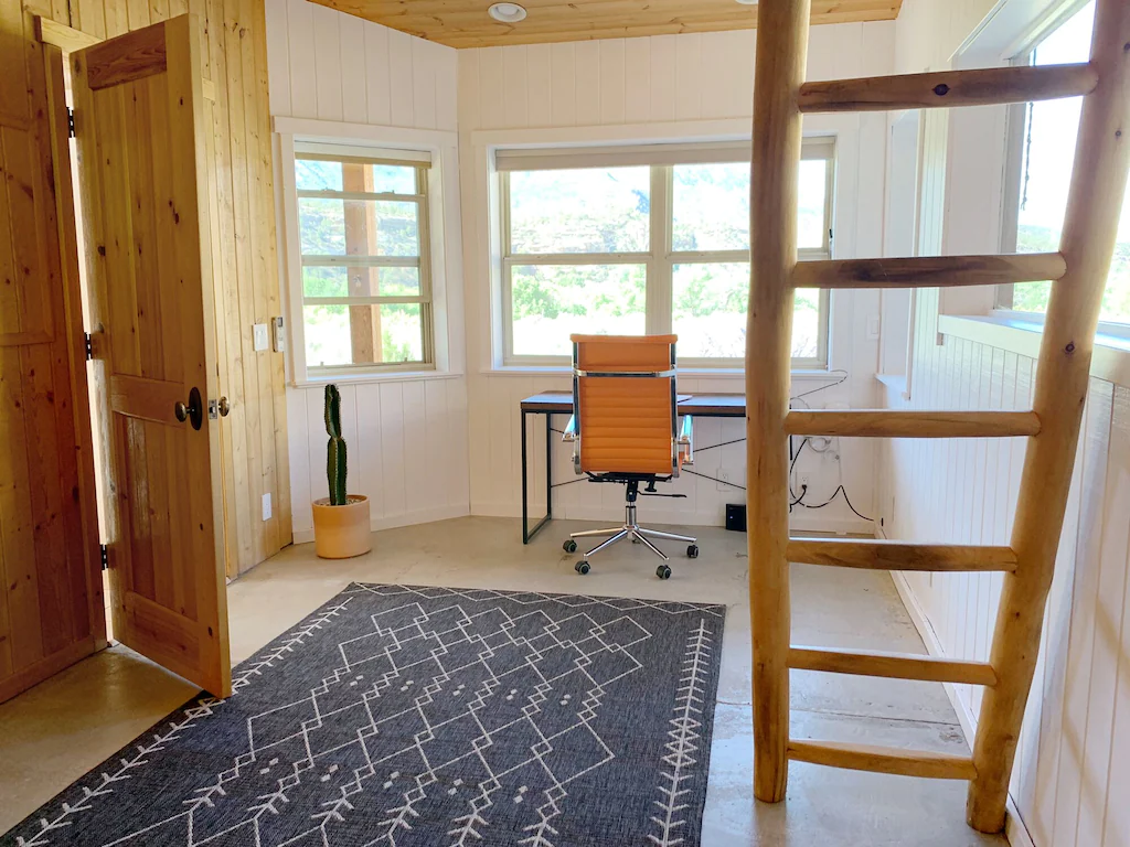 Office with desk, and ladder to sleeping loft.