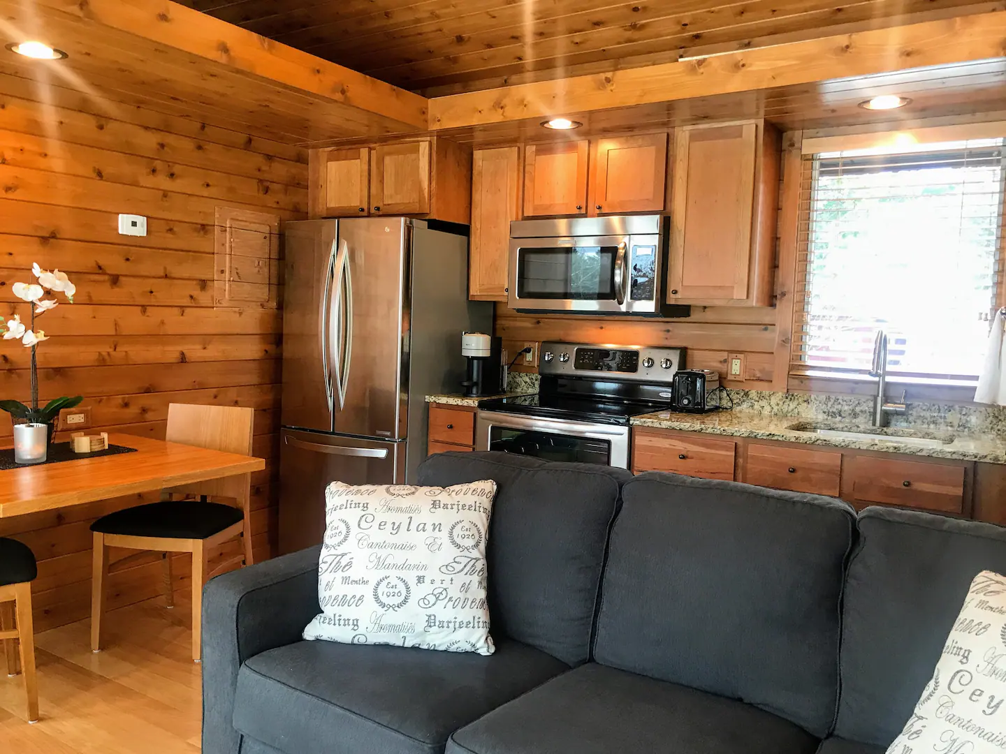 Tiny's kitchen is outfitted with full-size stainless steel appliances, a Nespresso coffee maker, granite countertops, a designer faucet, and cherry cabinetry.