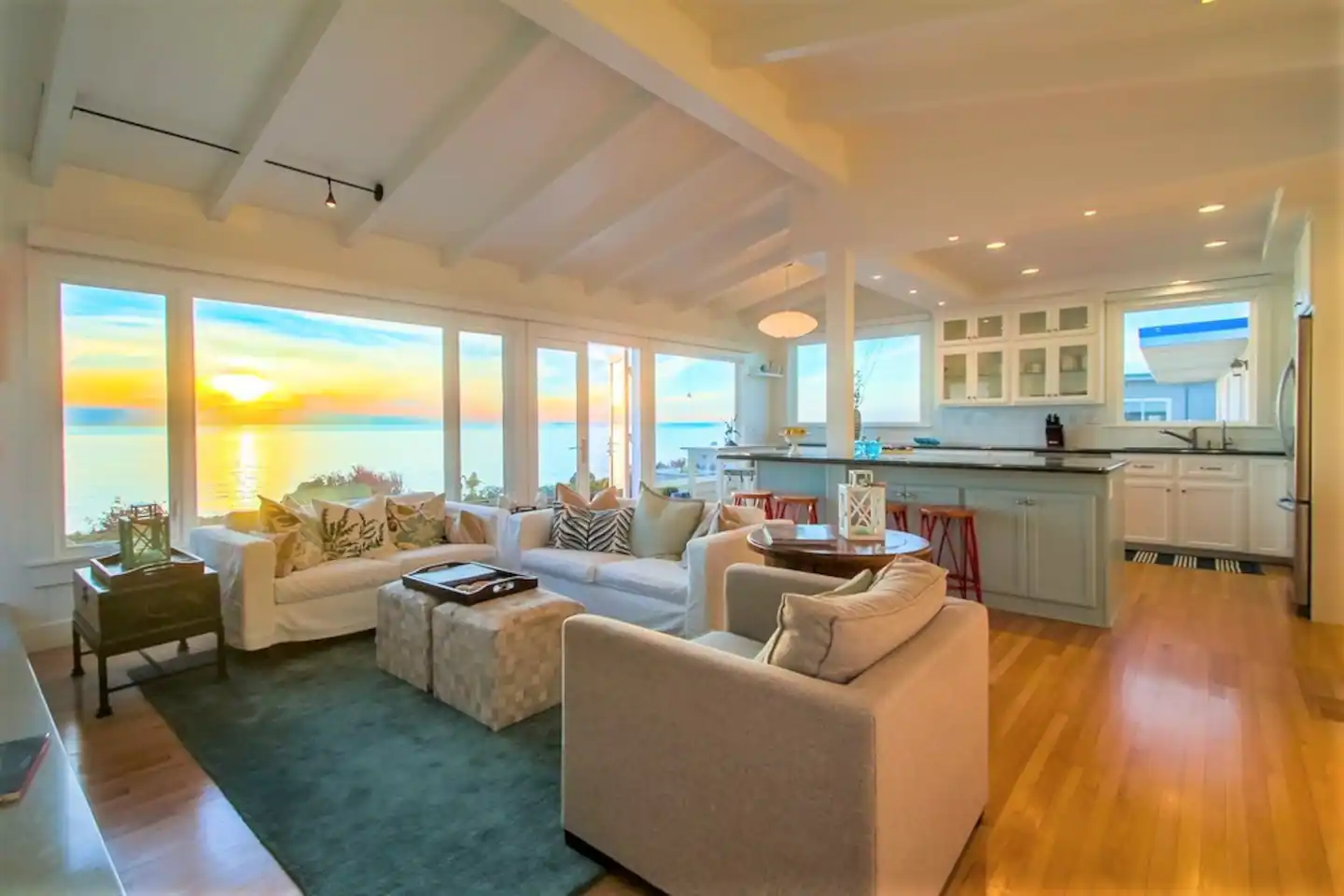 The living room is accented with arched open beam ceilings, cozy gas fireplace, hardwood flooring, and a flat screen smart TV.