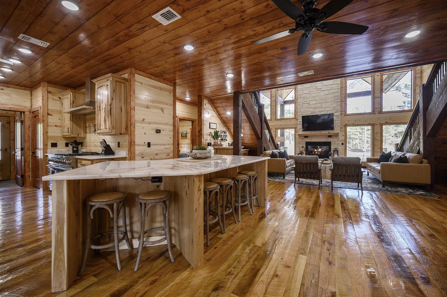 The kitchen island is equipped with six bar stools, and the dining table can comfortably seat up to twelve individuals.