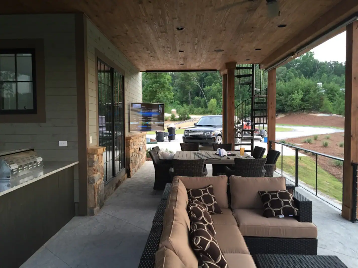 Outdoor patio with sliding screens and kitchen.