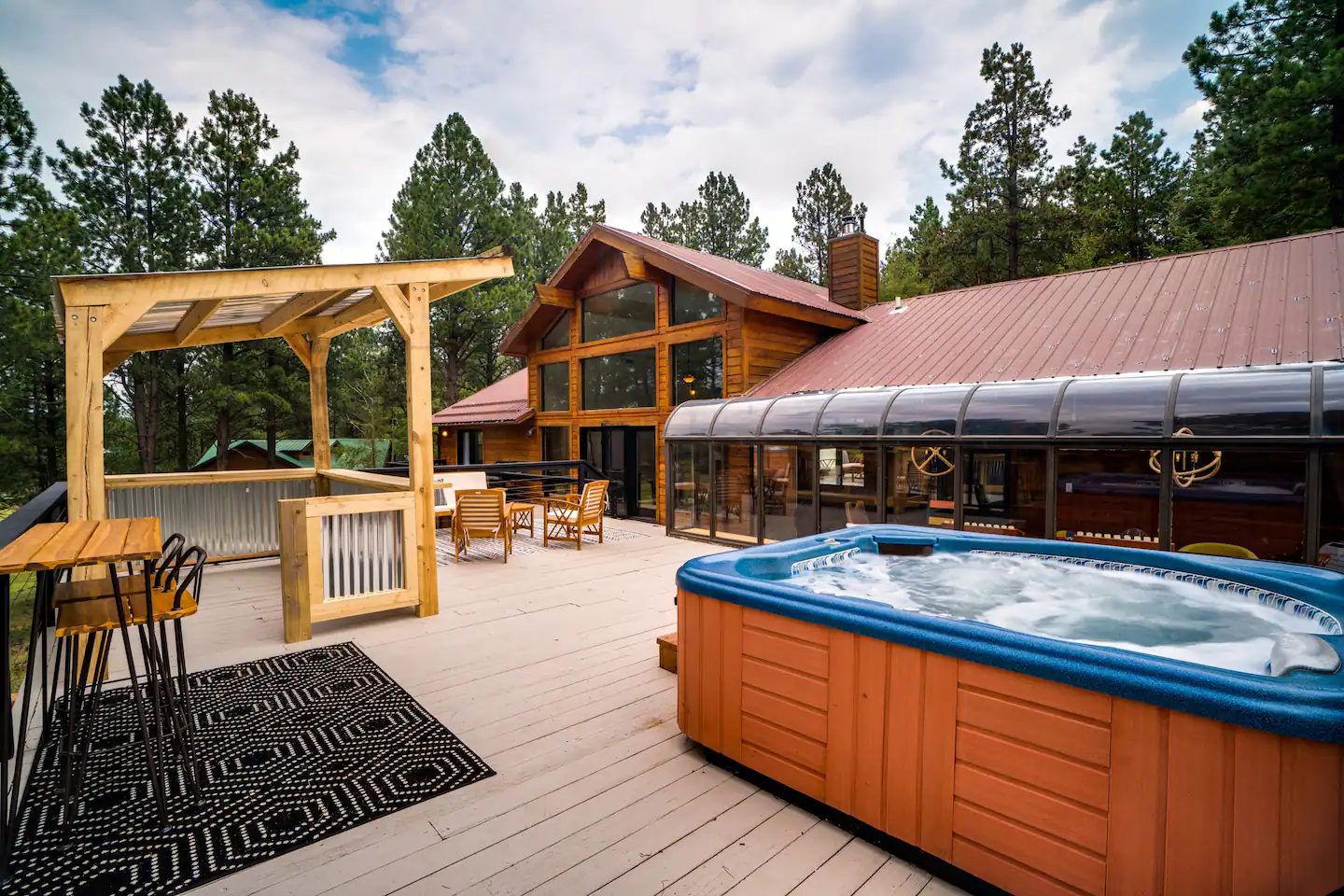 Private deck featuring a hot tub and bar.